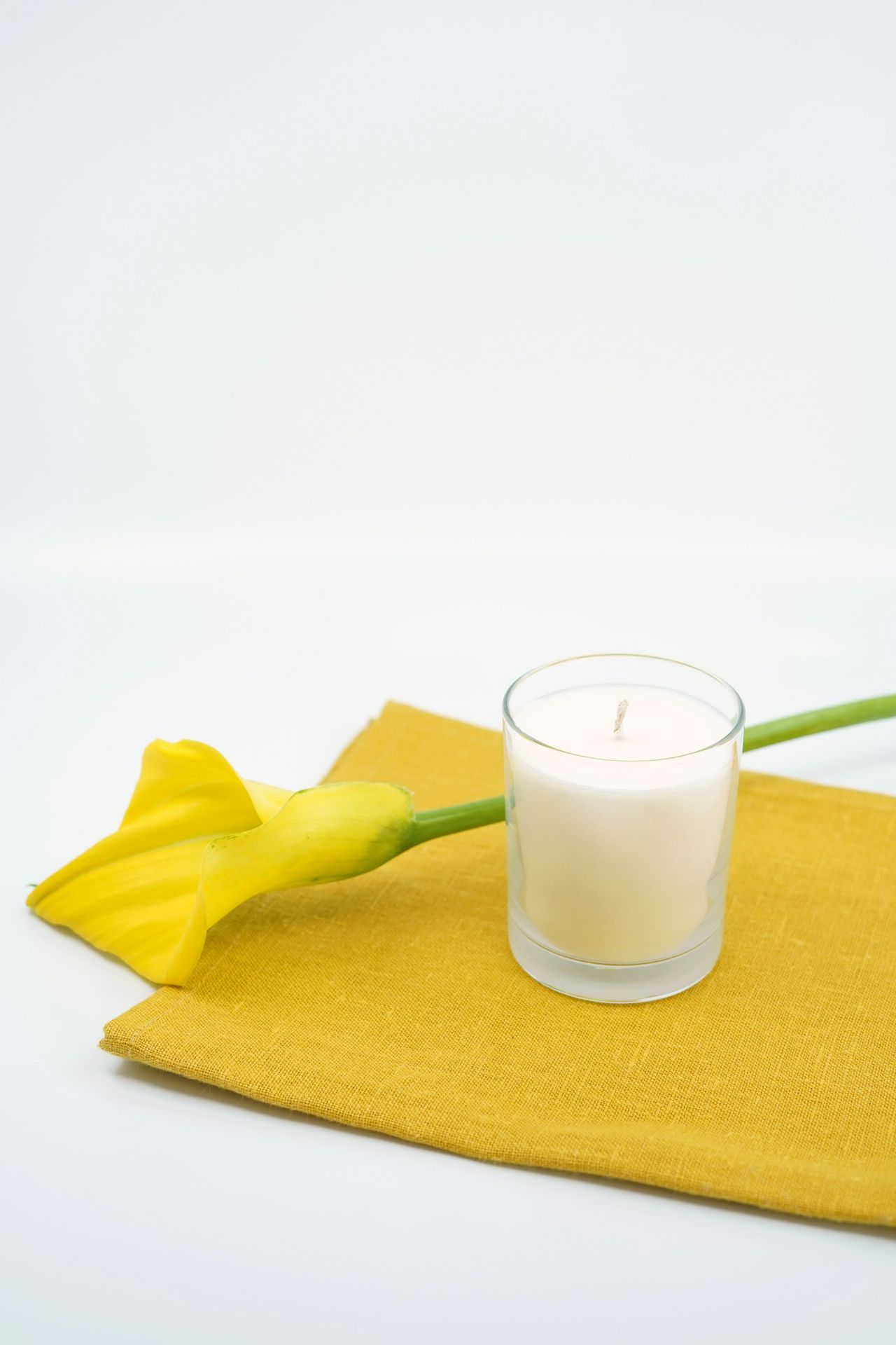 yellow textile beside clear drinking glass with white liquid